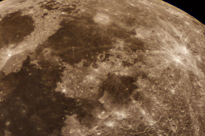 Bright lunar seas and crater rims illuminated against dark background