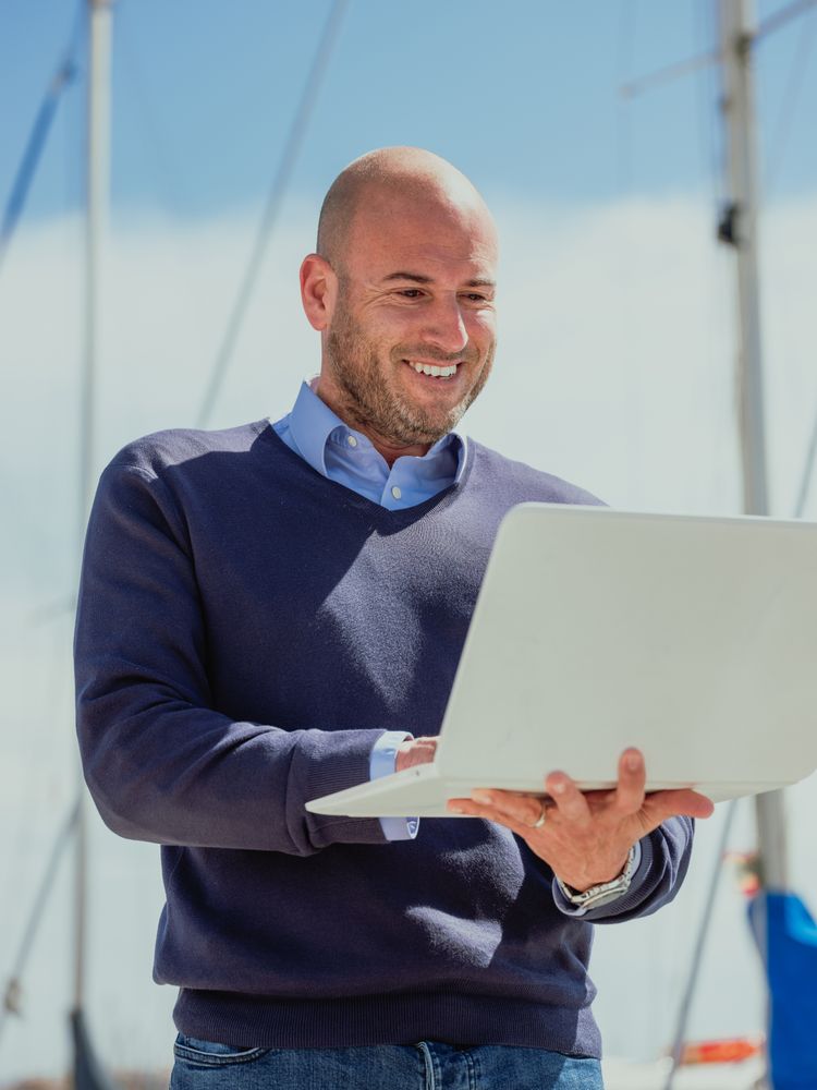 Businessman standing outside looking at the laptop