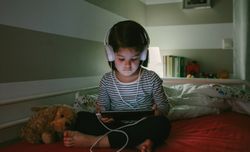 Girl with headphones looking at the tablet