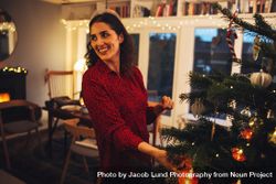 Woman looking away while decorating Christmas tree 5Qd6g0