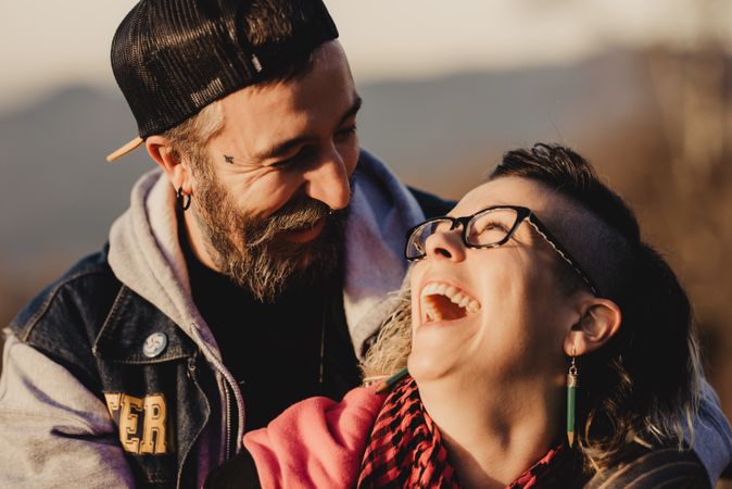 Happy couple hugging near tree in park