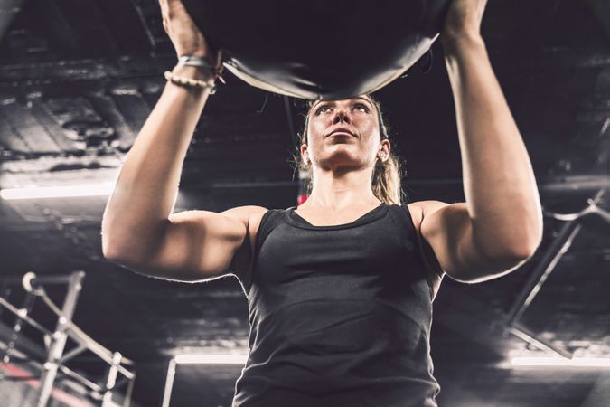 Muscular woman exercising with ball in gym
