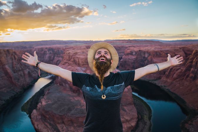 Traveler with outstretched arms near canyon