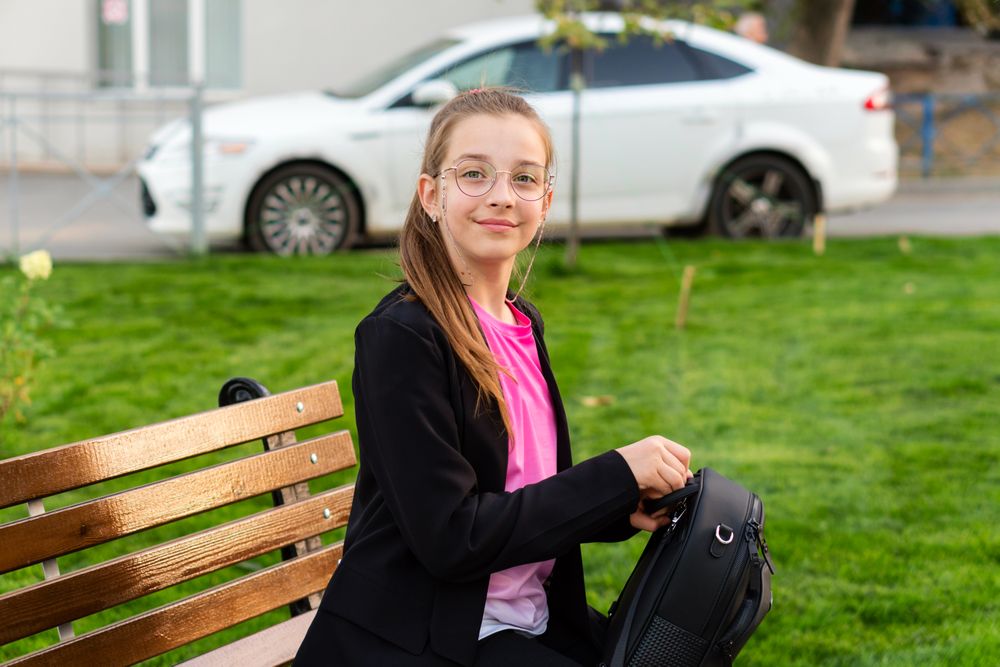 Girl packing her backpack in park.
