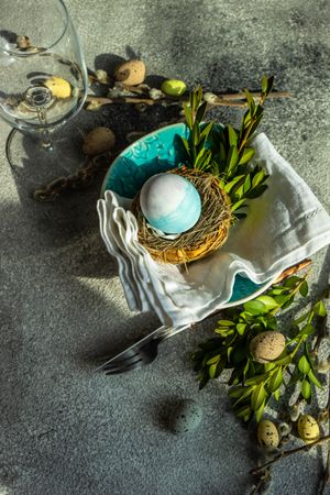 Easter table setting with blue egg in a nest on table