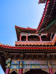A vibrant Chinese architectural temple with intricate red and gold details, ornate patterns