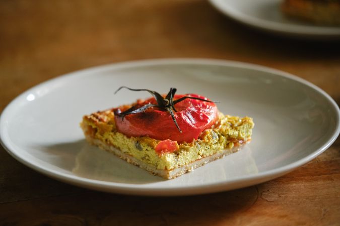Delicious vegetarian flatbread slice with tomato on plate