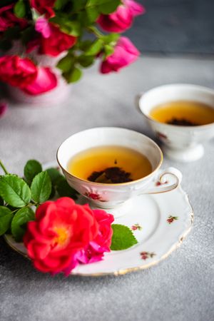 Tea in cup & saucer with red roses and copy space