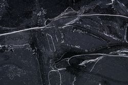 Fragment of thin ice on dark frozen river