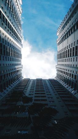 Upward View Between Two Skyscrapers Reaching for a Blue Sky