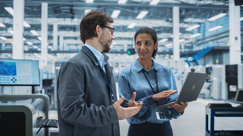 Colleagues talking in store over computer
