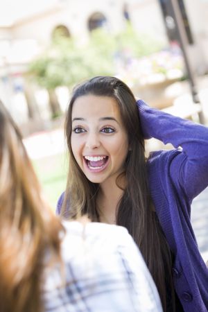 Expressive Young Woman Sitting and Talking with Girlfriend