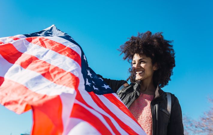 Black woman with afro hair and an american flag