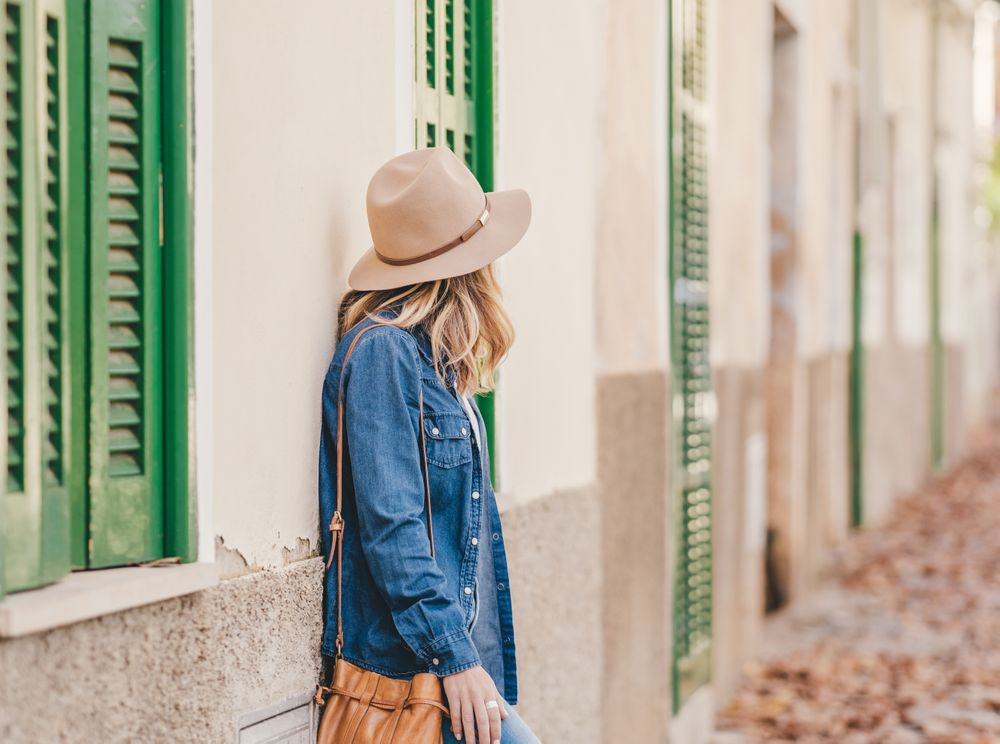 Woman leaning on stone house