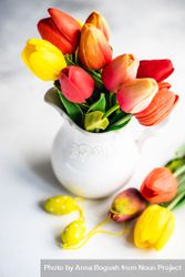 Easter concept of tulips in vase with yellow egg ornaments bGR3Gx