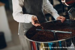 Man in apron roasting coffee beans 0vAQgb