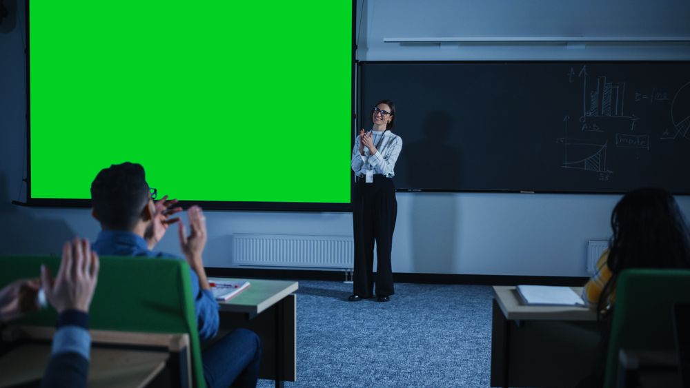 Young University Professor Explaining a Lecture, Pointing on a Green Screen Mock Up Display.