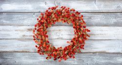 Wreath made of natural burdock flowers on light aged wood