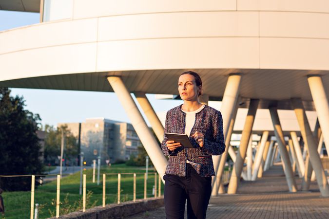 Confident entrepreneur with tablet on city street
