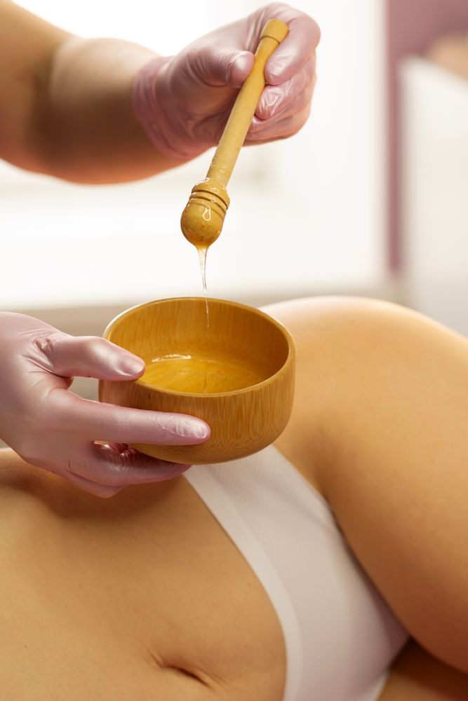 Gloved therapist lifts honey mixture with wooden dipper