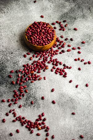 Bowl of dried kidney beans spilling onto grey counter