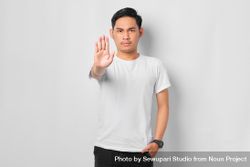 Asian male in grey studio gesturing to stop 4Z1Bx5
