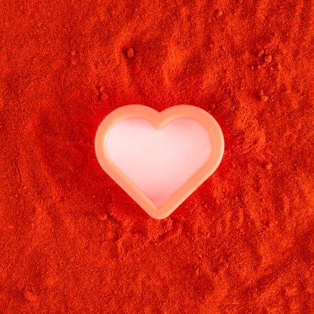 Plastic heart shape surrounded by red soil