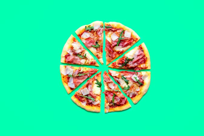 Homemade ham pizza minimalist on a green background
