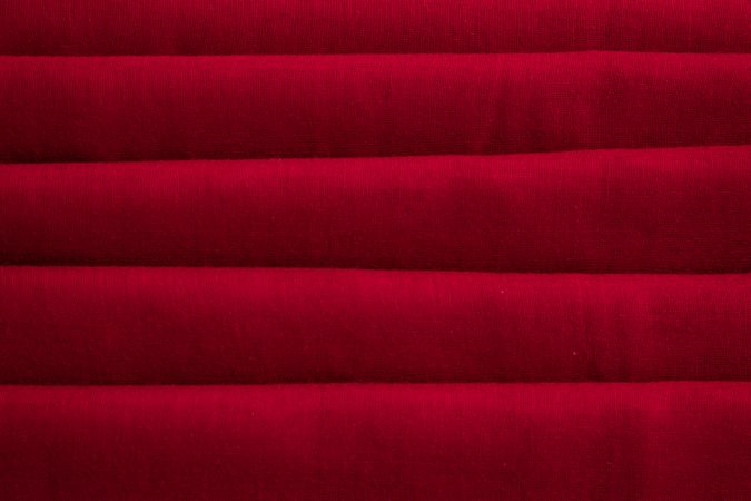 Close up Red folded Fabric Background Texture.