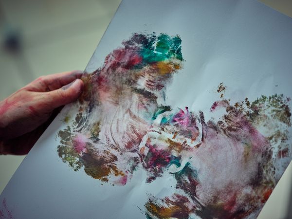 Crop person holding painted paper