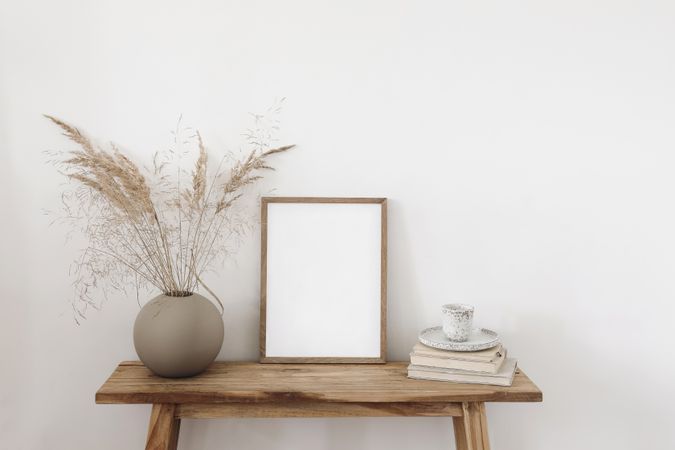 Entryway table with mockup poster and vase and decorative reeds