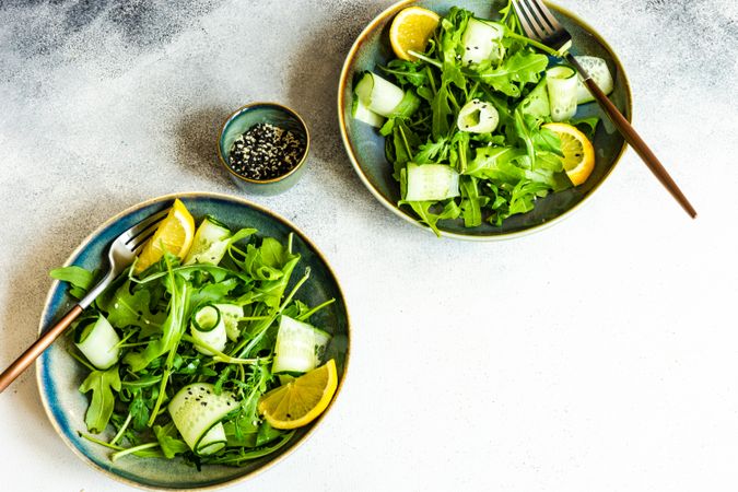 Top view of two healthy vegetable salad with arugula and avocado