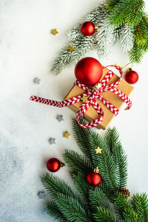 Top view of marble counter with Christmas present wrapped with red string, vertical composition