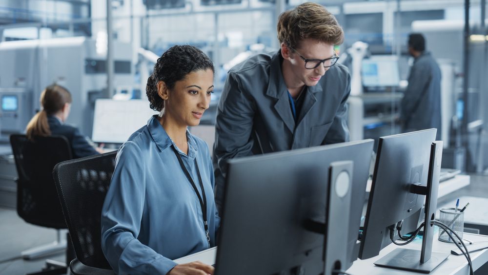 White Man and Hispanic Woman Having Conversation at Industrial Facility.