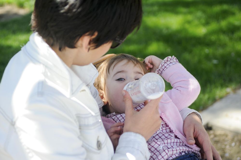 Woman feeding girl in park