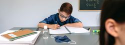 Boy writing in his notebook at school