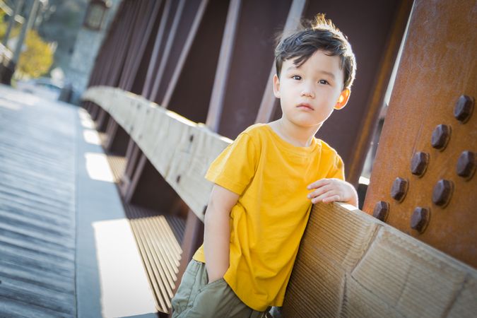Boy Leaning on Bridge Outdoors