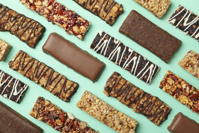 Flat lay with tasty granola bars on mint background, top view