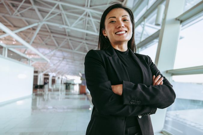 Smiling woman waiting for her flight at airport terminal