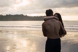 Young couple embracing on the beach at sunset