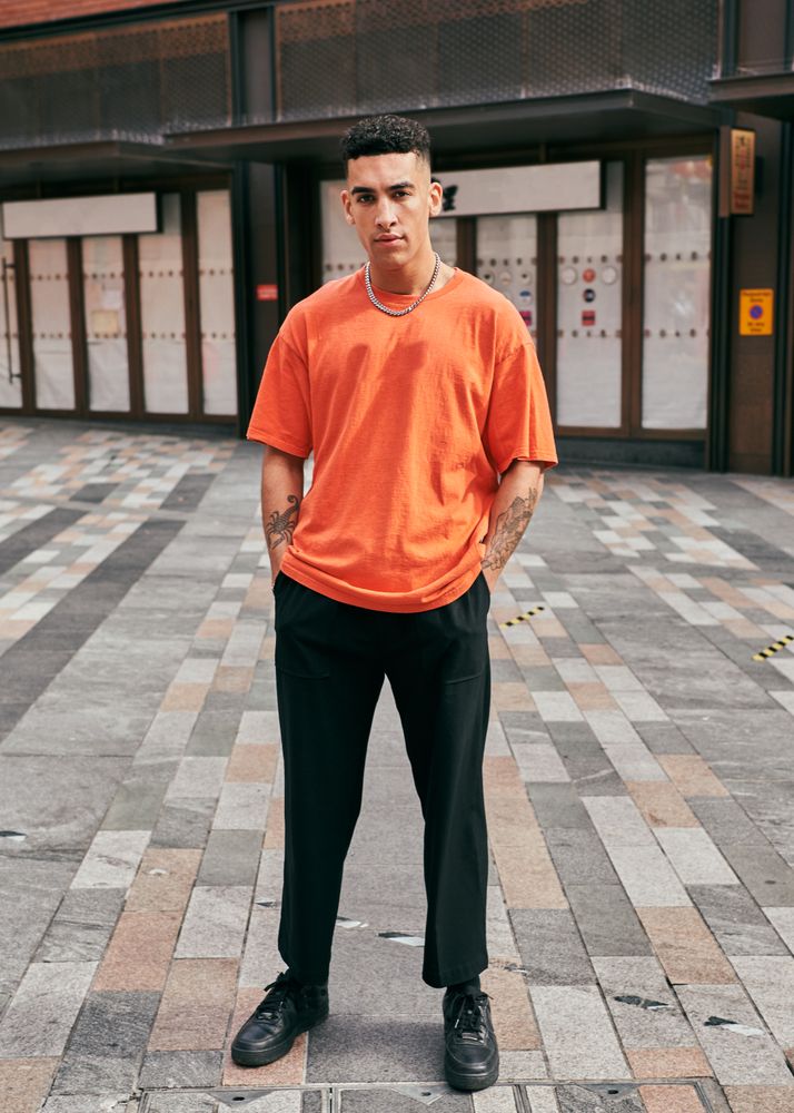 Young man with tattoes posing on the street