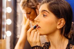 Glamorous female applying lipstick