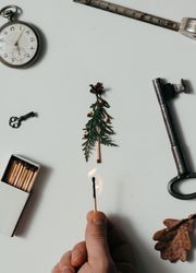 Creative arrangement of vintage items on desk with hand lighting match