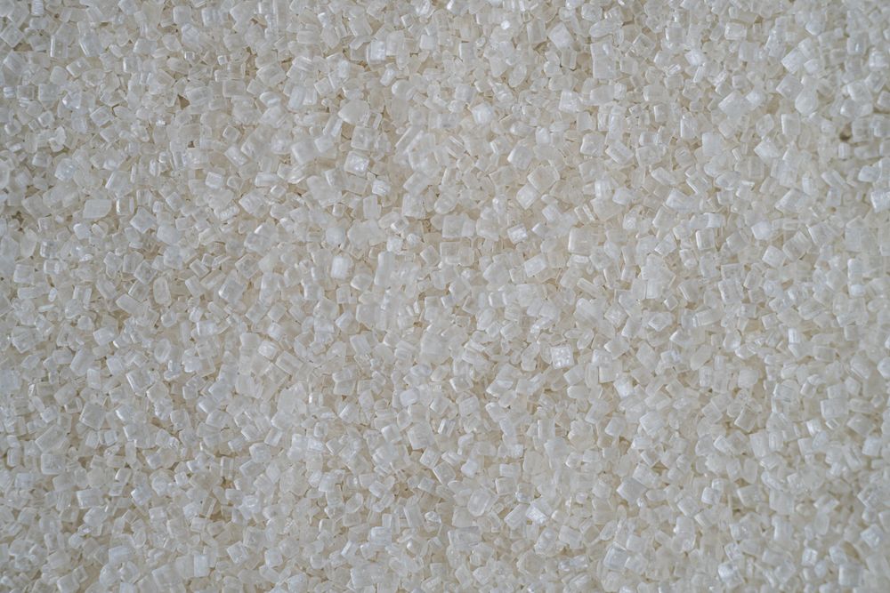 Flatlay of scattered granulated sugar