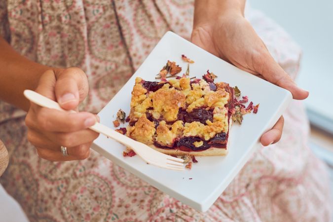 Crop woman eating delicious dessert