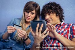 Couple thinking about making an online purchase with tablet 0JGo6r