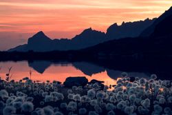 Calm lake in sunset light surrounded by mountains