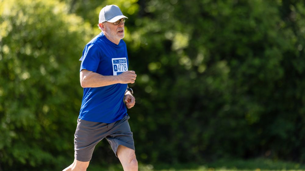 Portrait of a Older Male Jogger Running in a Park on a Health Trail.
