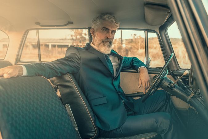 Man in suit jacket sitting on car seat
