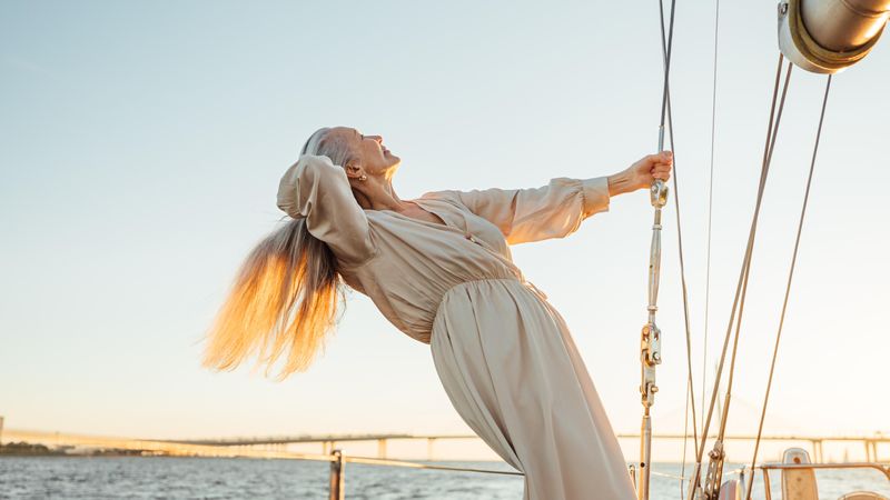 Woman leaning back on yacht with her hand in her hair